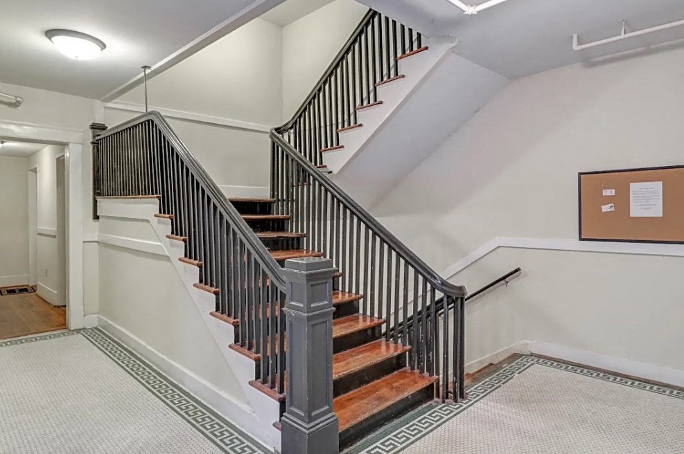 a stairwell in a home with a railing and a wooden staircase