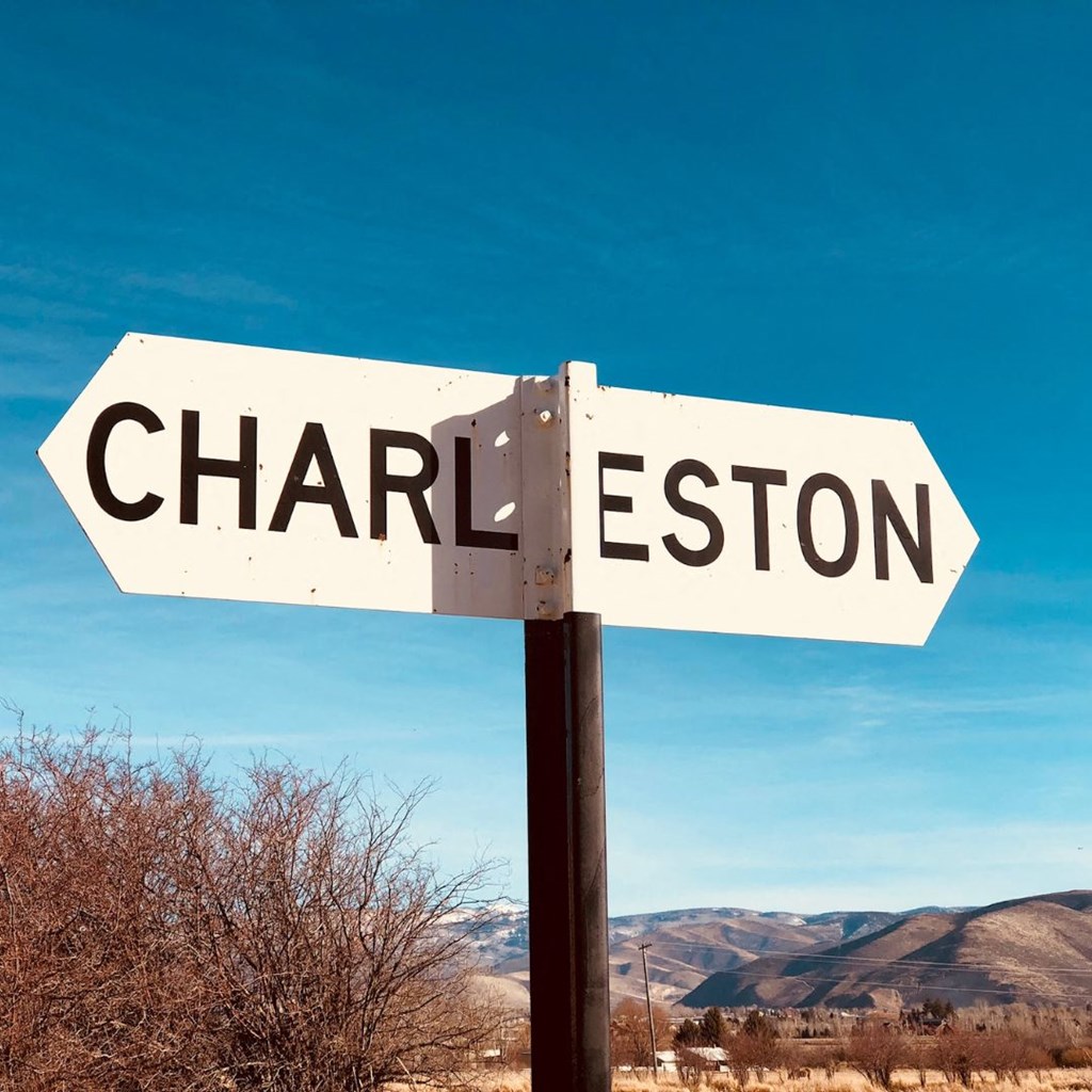 a street sign that reads in front of the mountains