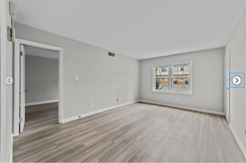 the living room of an empty apartment with wood floors and a window
