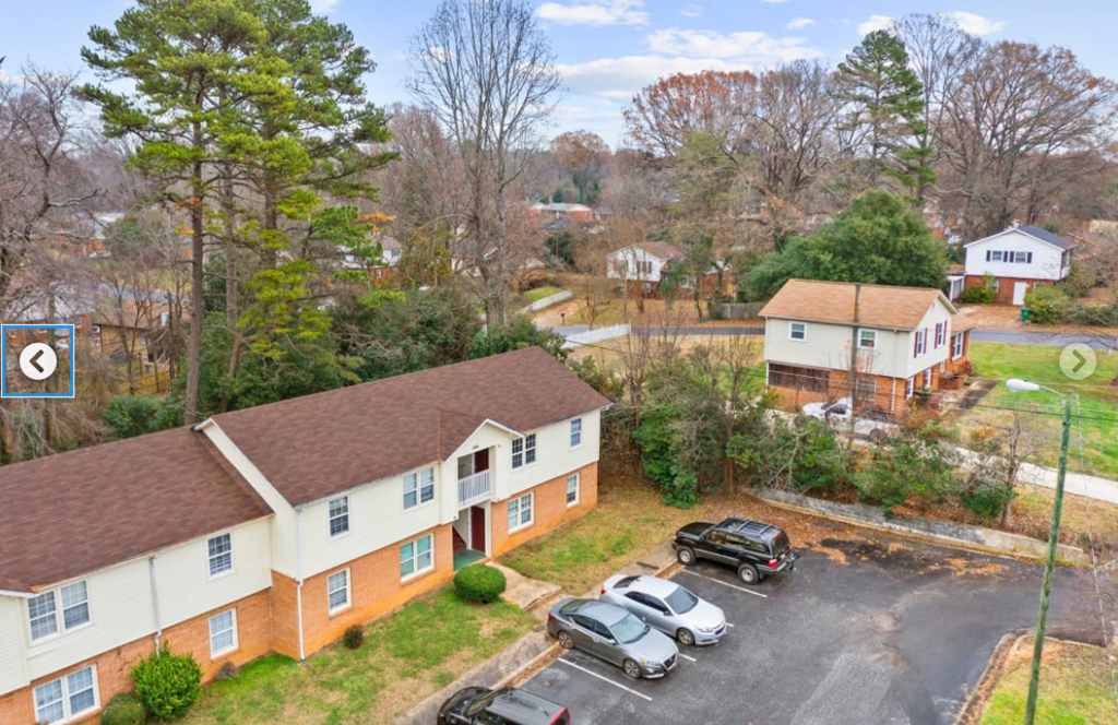an aerial view of a house with cars parked in front of it
