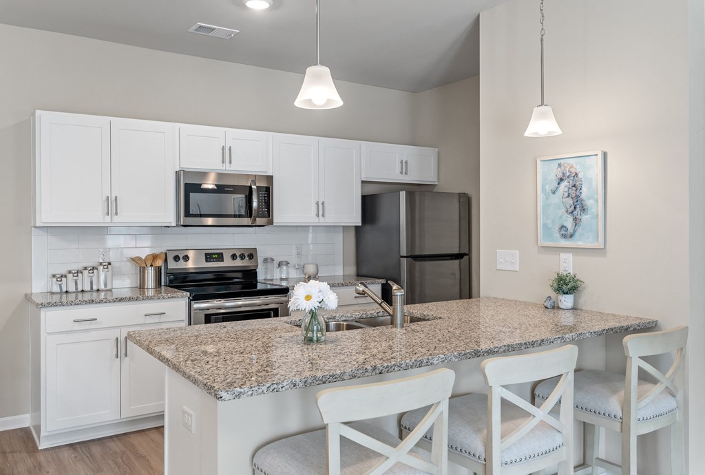 a kitchen with white cabinets and a granite counter top