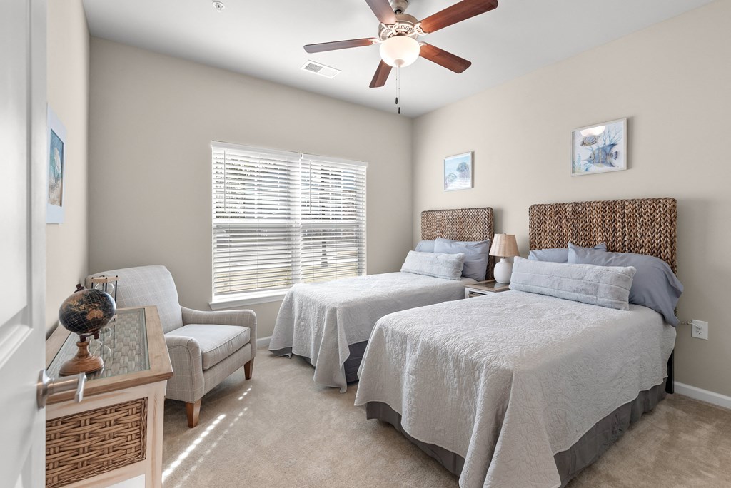 a bedroom with two beds and a ceiling fan