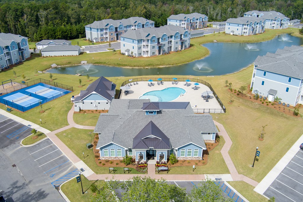 an aerial view of a community with a swimming pool and a lake