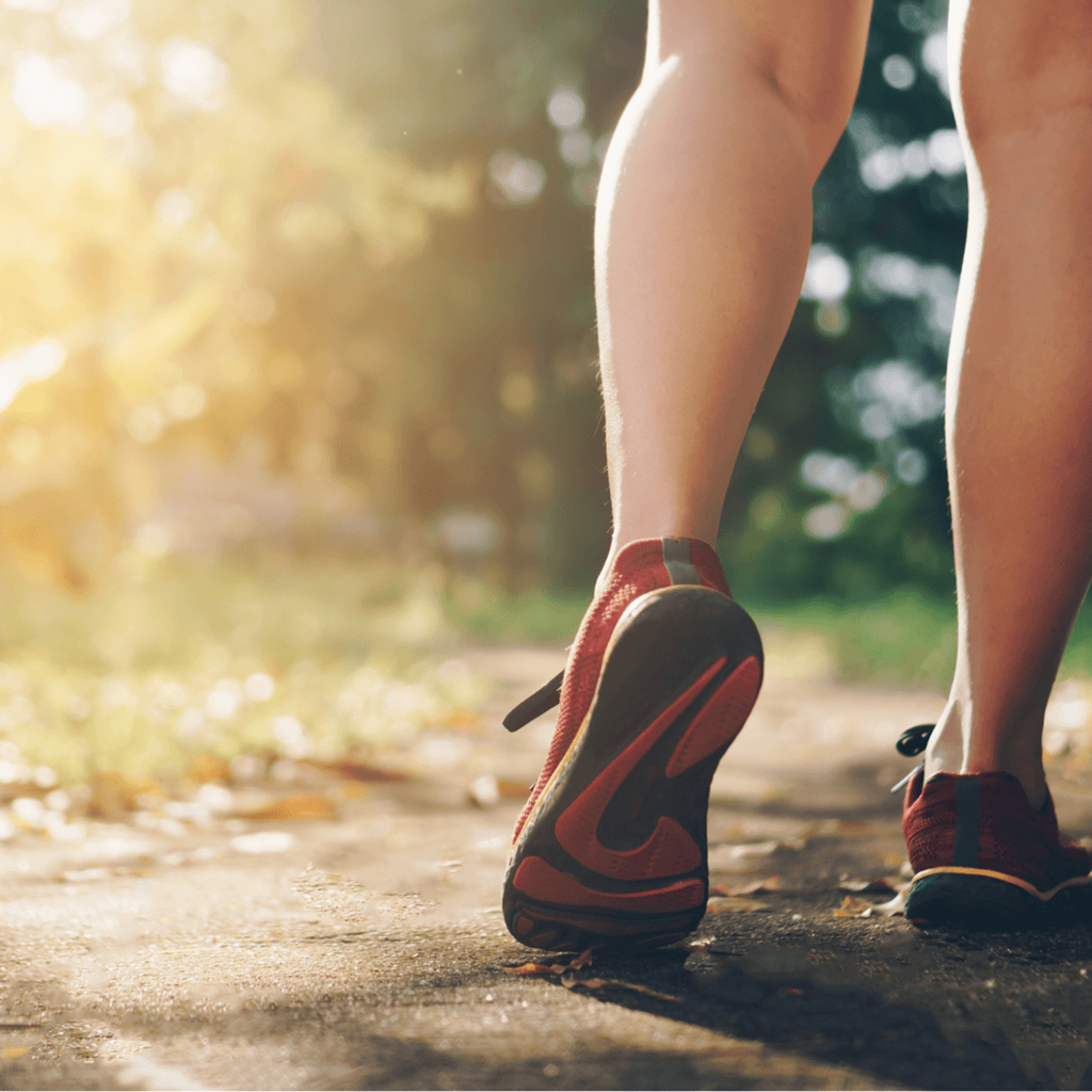 a woman walking down a path with her shoes on