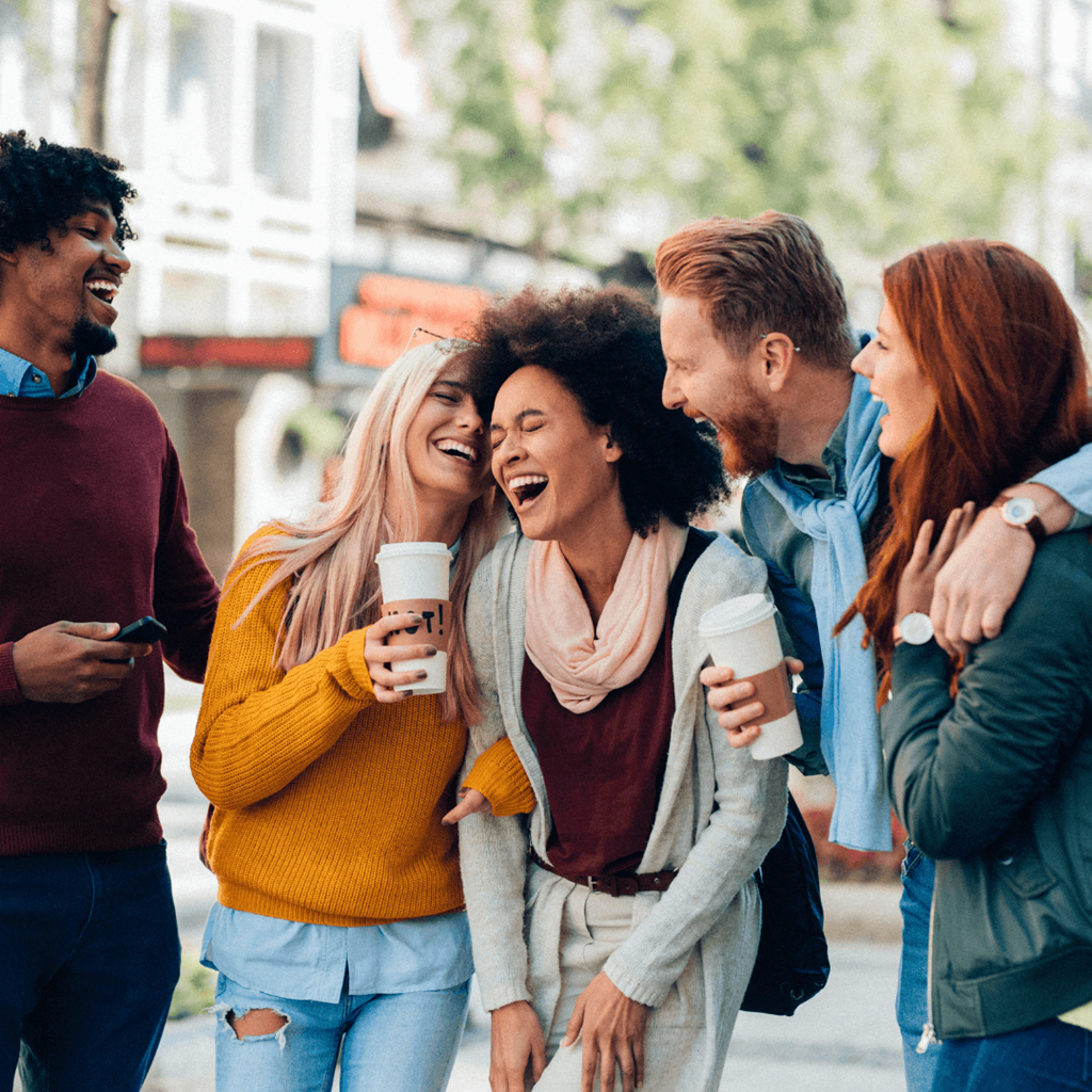 a group of people laughing and drinking coffee
