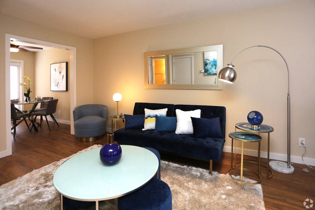 a living room with a blue couch and a white table