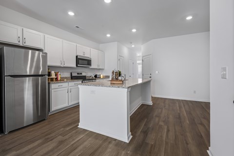 A kitchen with white cabinets and a wooden island.