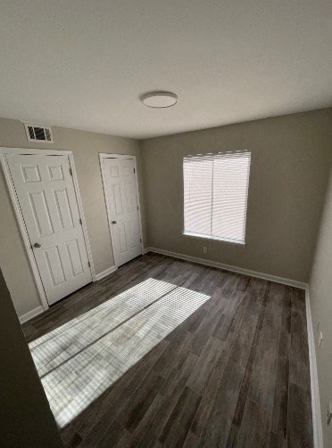 an empty room with wooden floors and a window