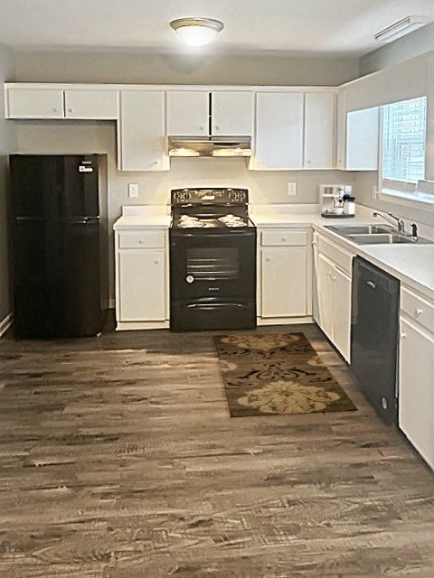 a kitchen with white cabinets and black appliances