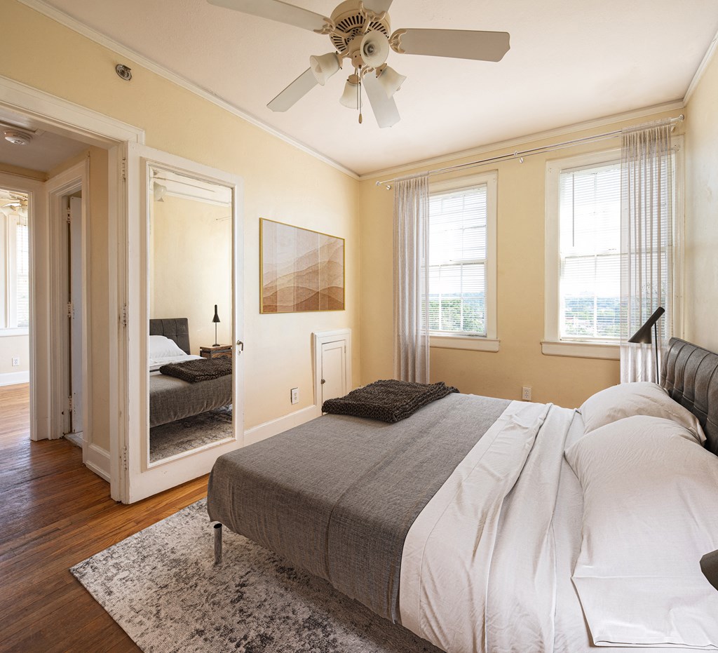 a bedroom with a bed and a ceiling fan