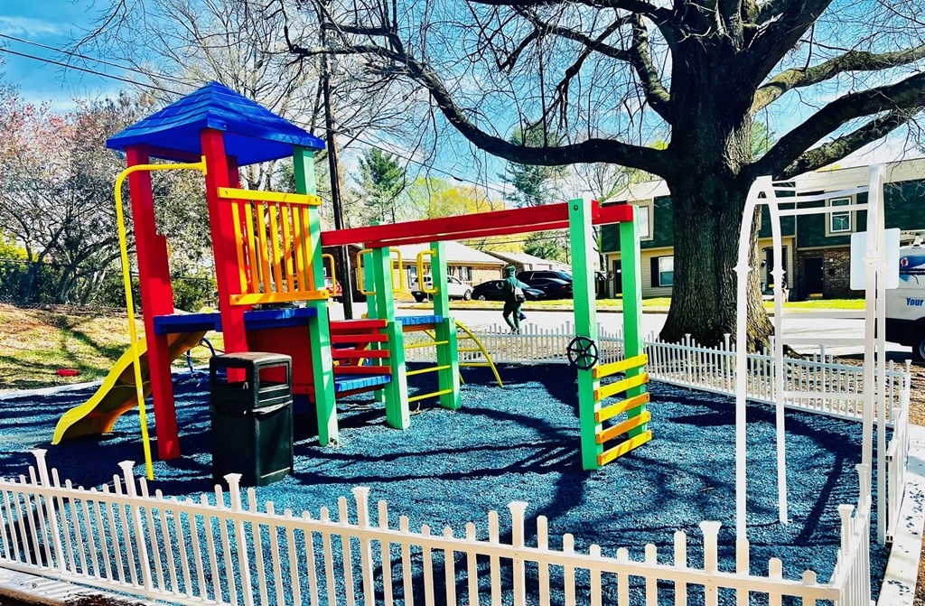 a playground with colorful structures and a tree