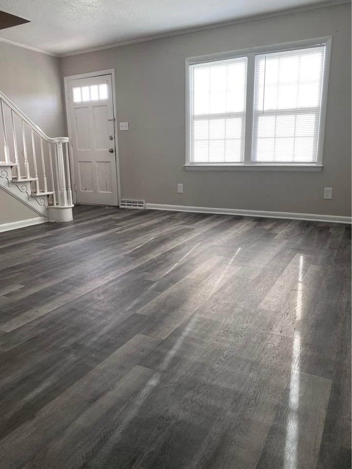 a living room with a hard wood floor and a white door
