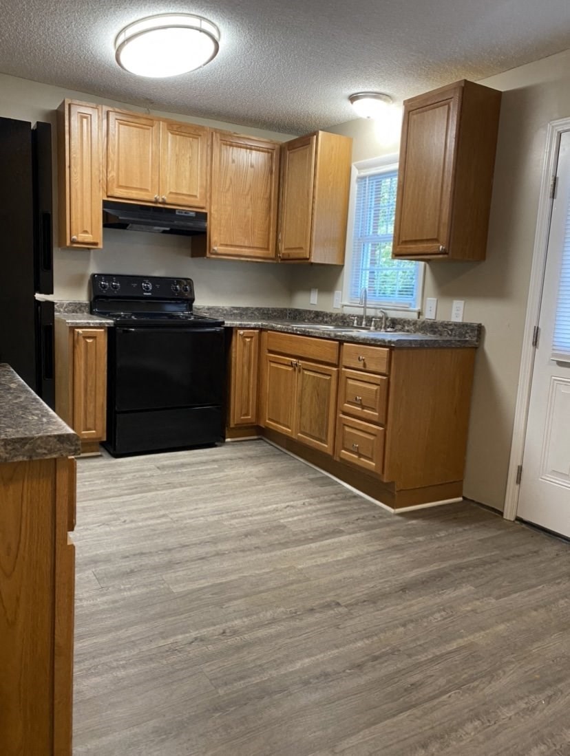 a kitchen with wooden cabinets and a black stove top oven