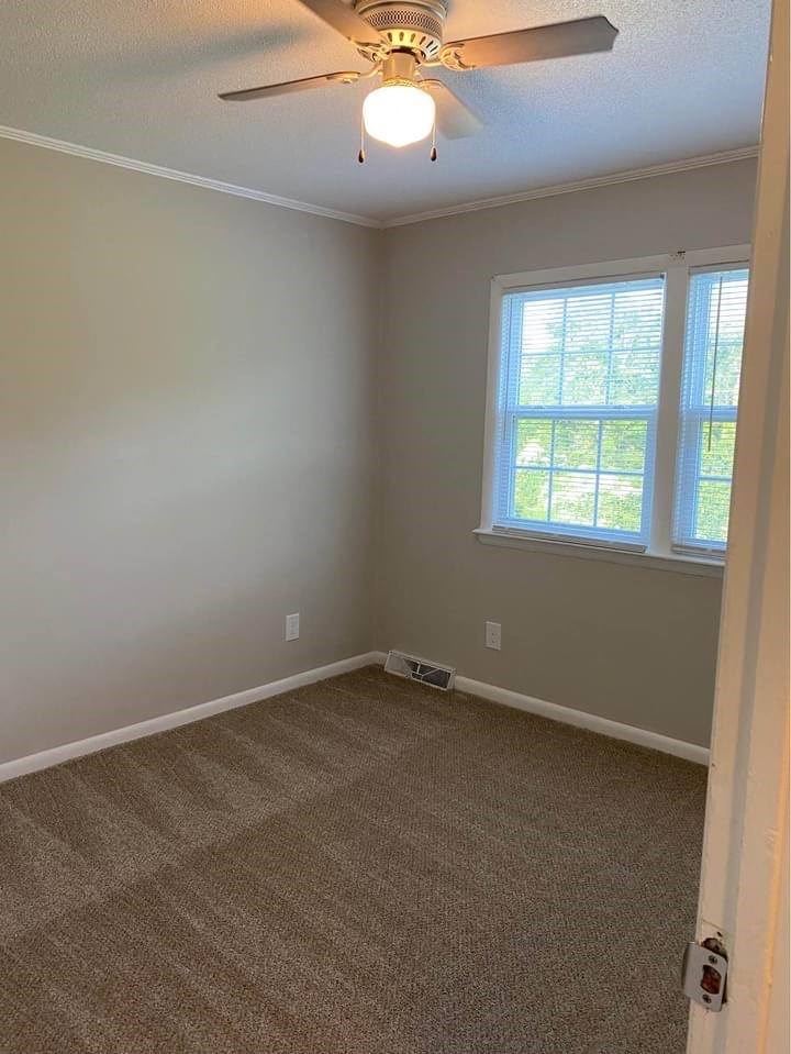 an empty room with a ceiling fan and two windows