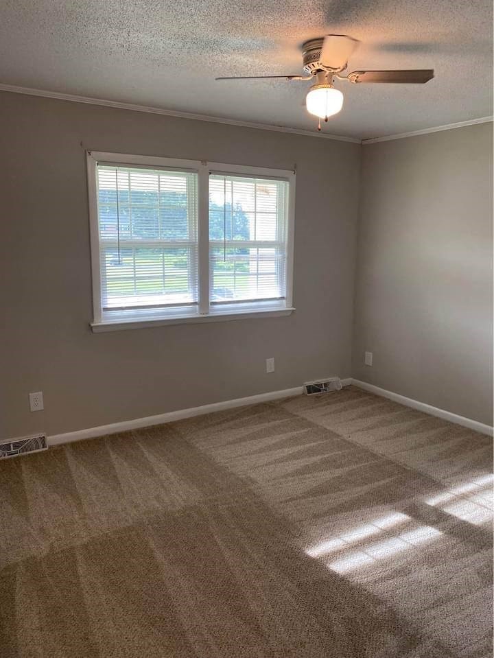 a bedroom with a ceiling fan and two windows