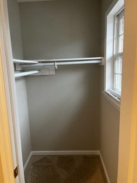 an empty closet with a window and a white door
