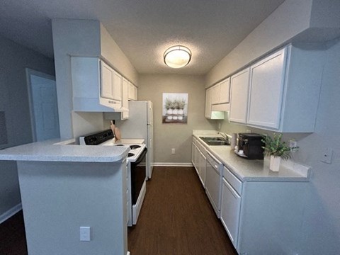 a kitchen with white cabinets and a stove and a refrigerator
