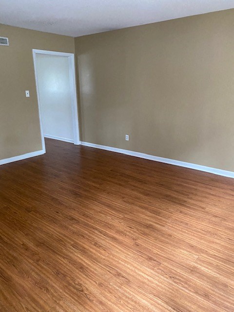 an empty living room with wood floors