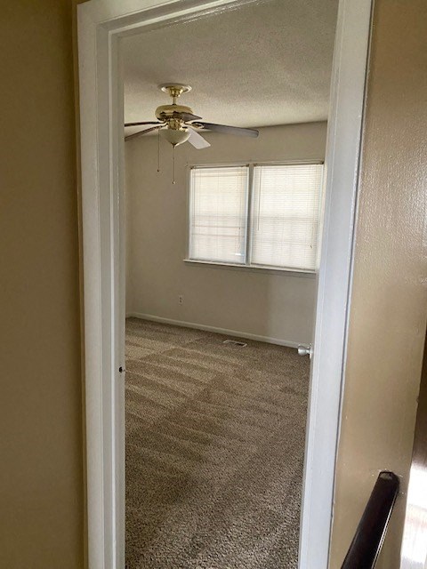 an empty room with a ceiling fan and a window