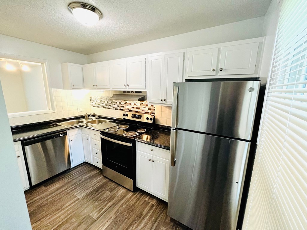 a kitchen with stainless steel appliances and white cabinets