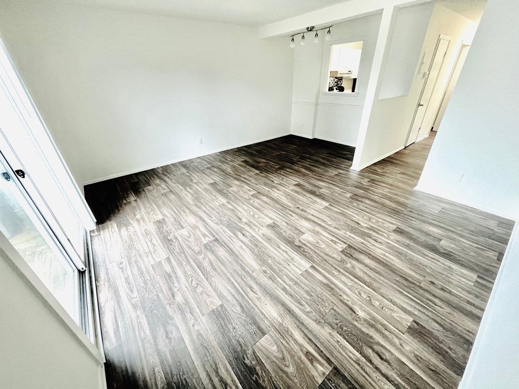 the living room of a new home with wood flooring