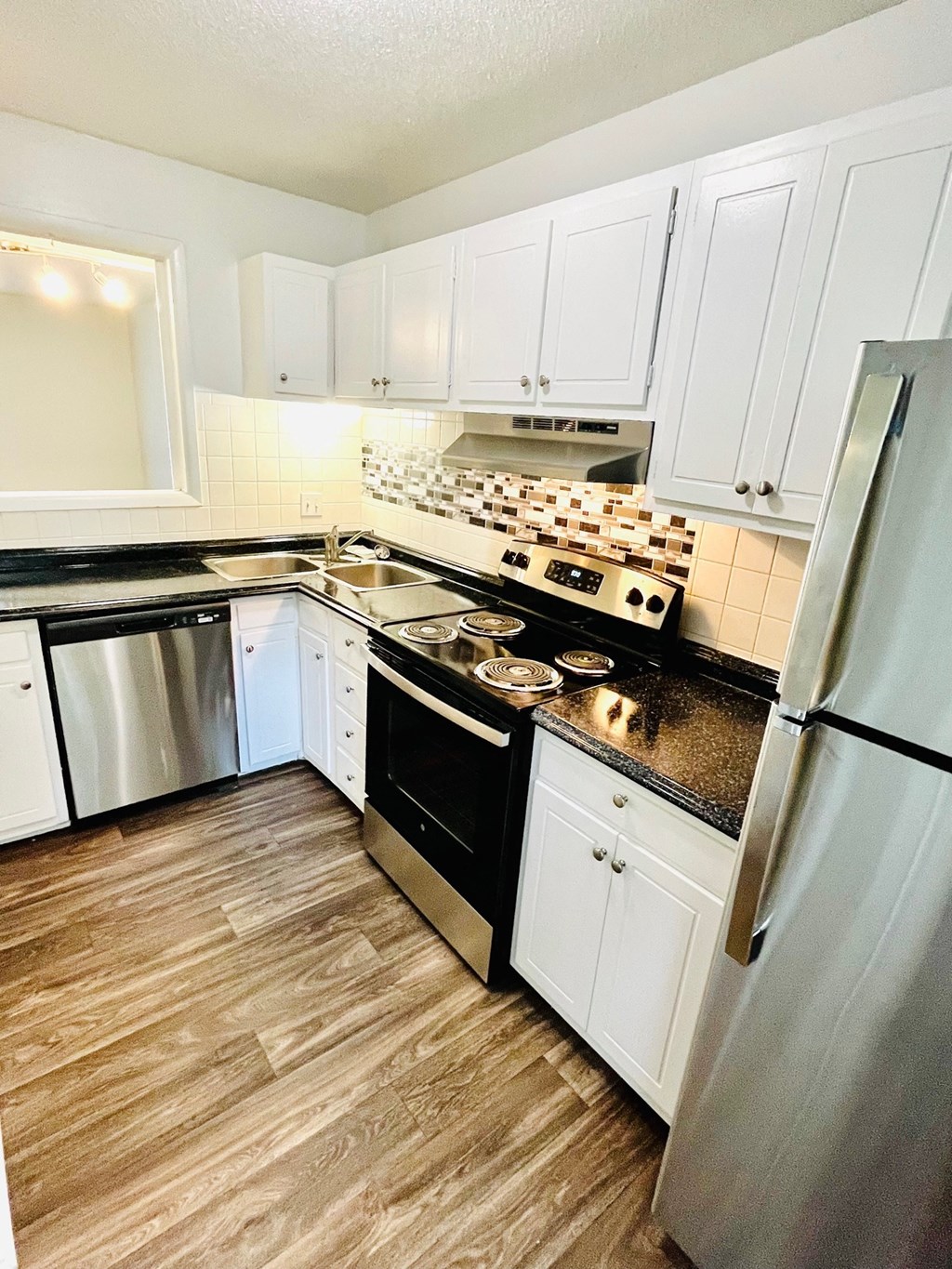a kitchen with stainless steel appliances and white cabinets