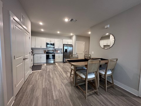A kitchen with a dining table and chairs.