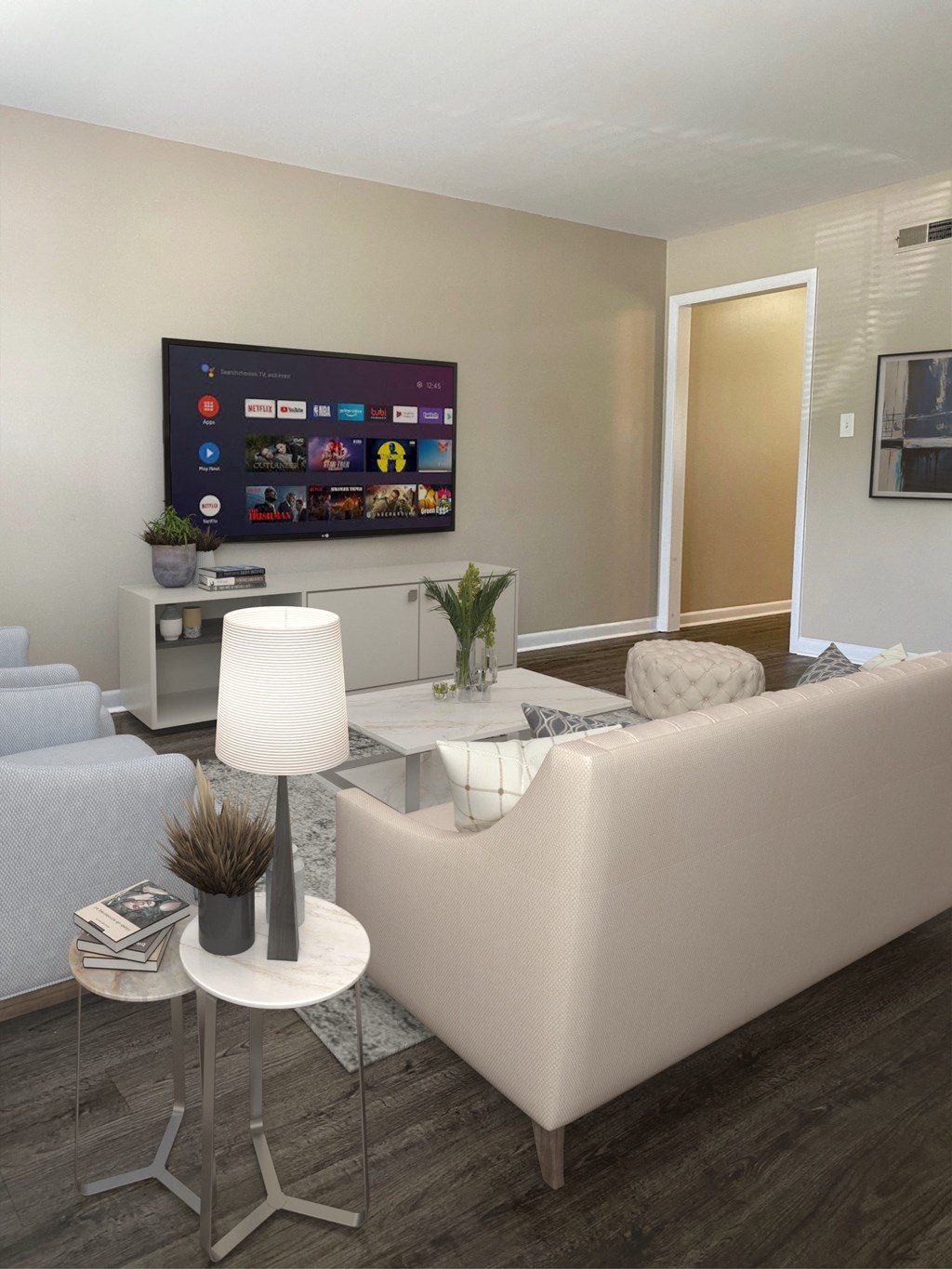 a living room with white furniture and a tv on the wall