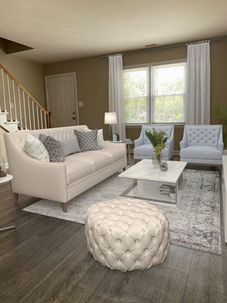 a living room with white couches and chairs and a white coffee table