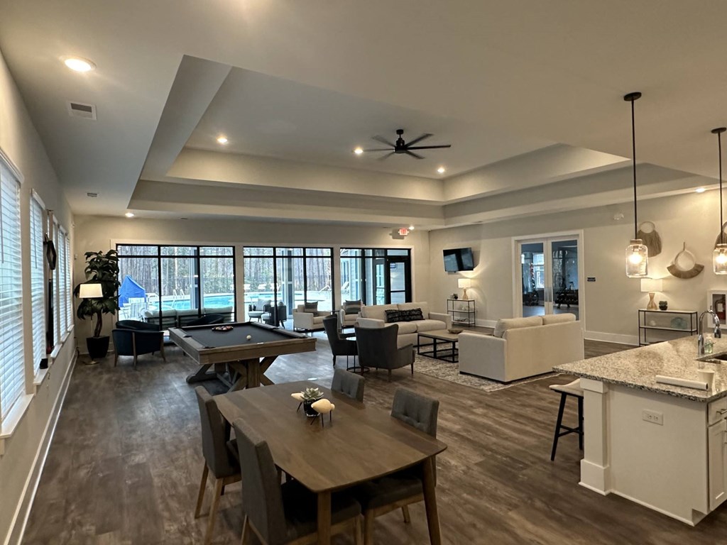 A spacious living room with a dining table and chairs.
