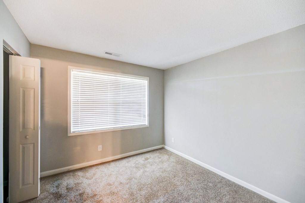 an empty room with a window and a door