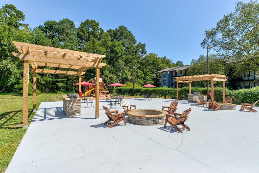 a large patio with chairs and a fire pit