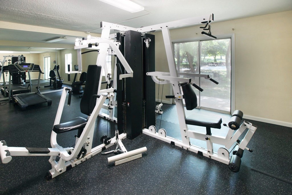 a gym with weights and other equipment in a room with a window