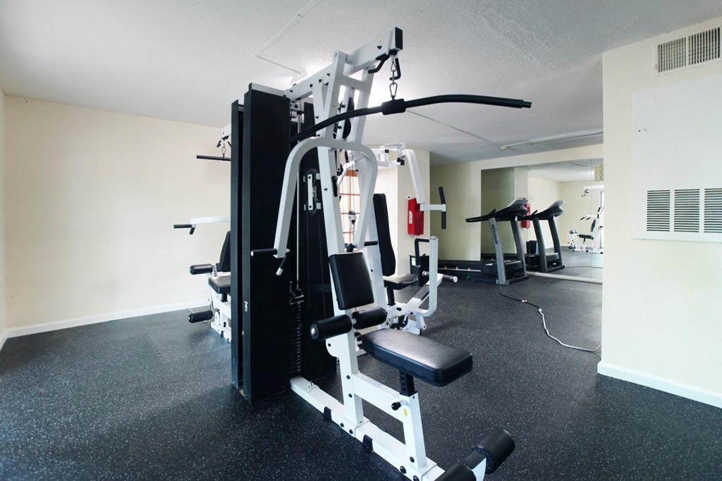 a gym with weights and other equipment in an empty room