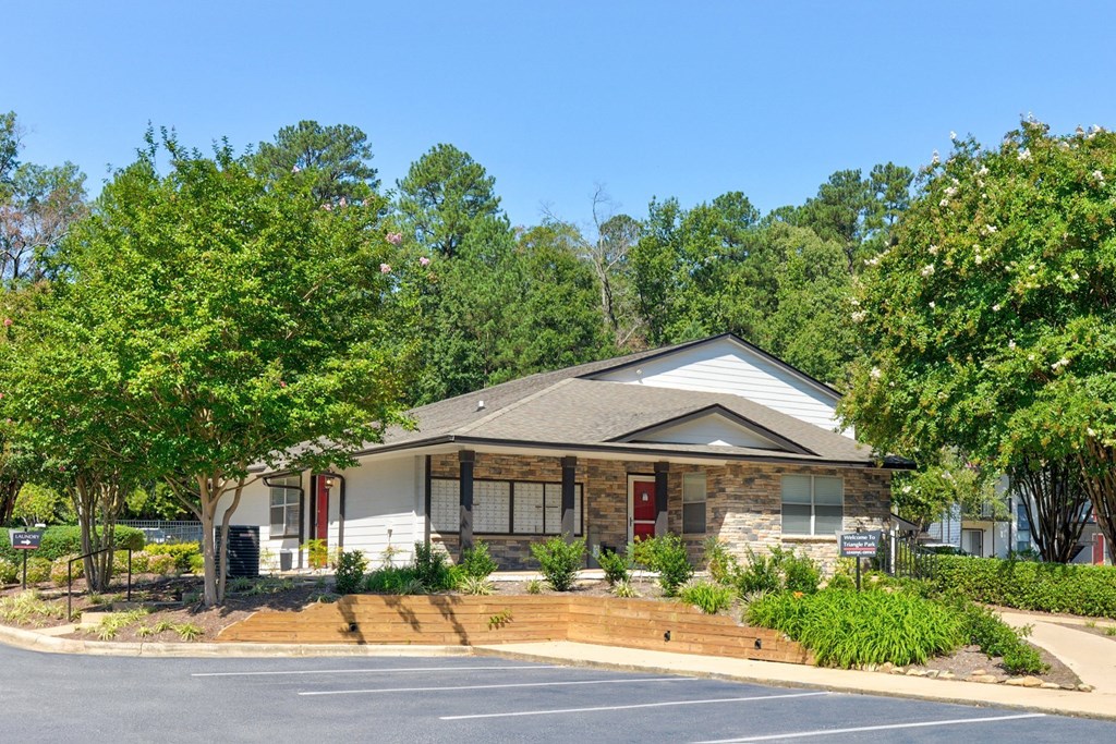 a house with a driveway and trees in front of it