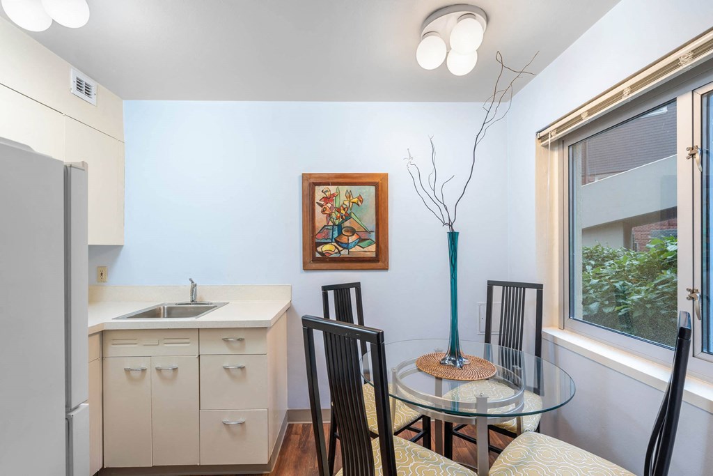 a kitchen and dining room with a glass table and chairs at Celio Apartments, Portland, Oregon