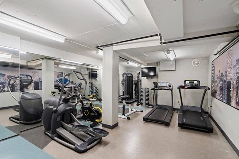the gym is equipped with cardio equipment and weights at Celio Apartments, Portland, Oregon