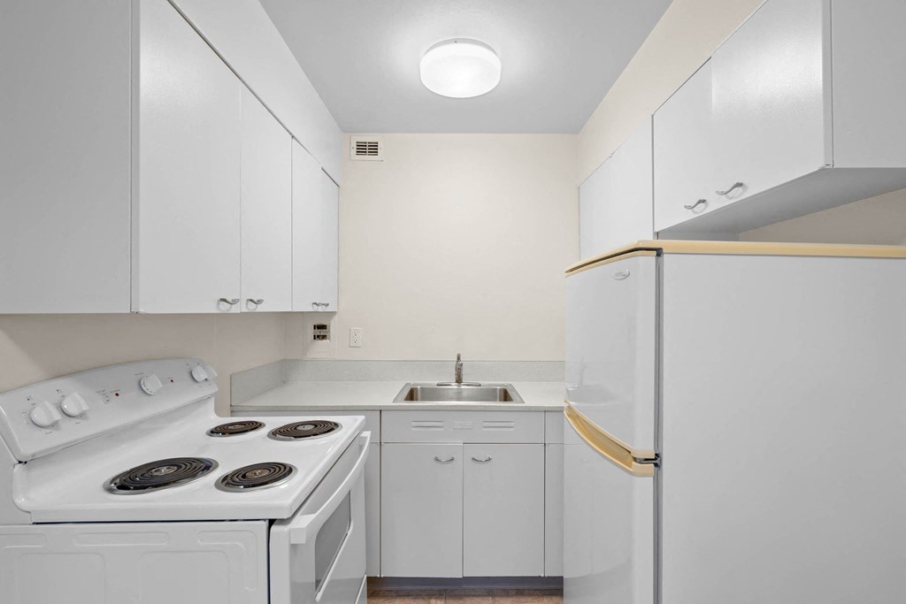 a white kitchen with white appliances and white cabinets at Celio Apartments, Portland
