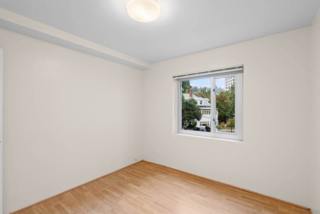 a room with white walls and a window and a wooden floor at Celio Apartments, Oregon