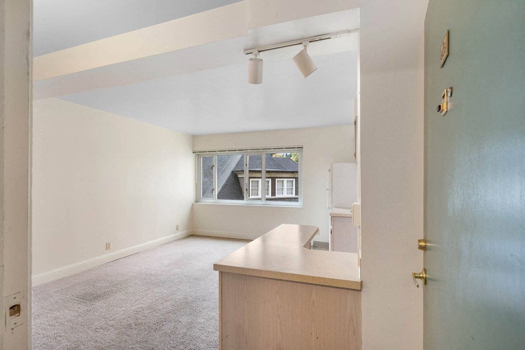an empty living room with a kitchen and a window at Celio Apartments, Portland, 97205