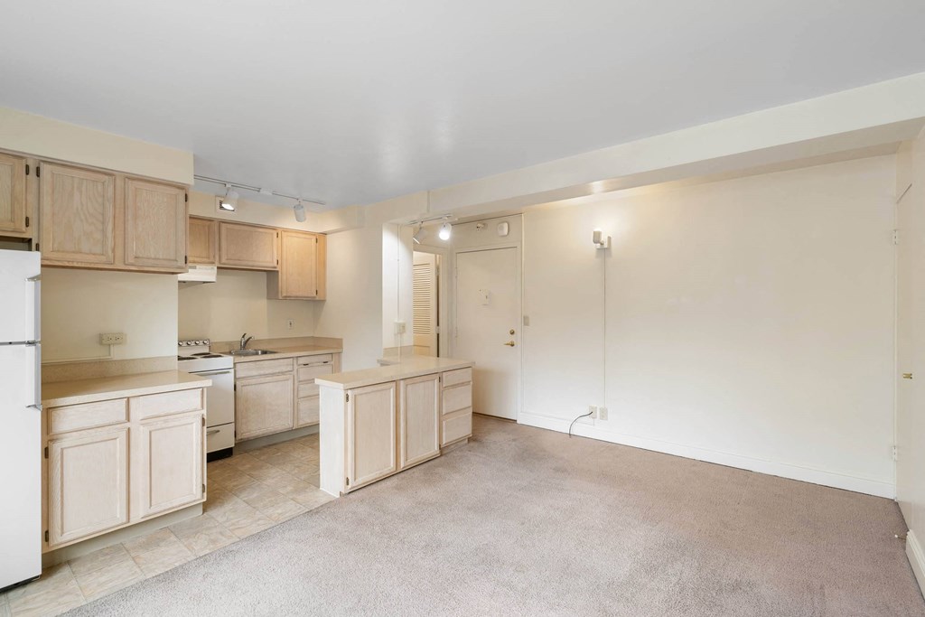 a kitchen with white cabinets and a sink and a refrigerator at Celio Apartments, Portland, 97205