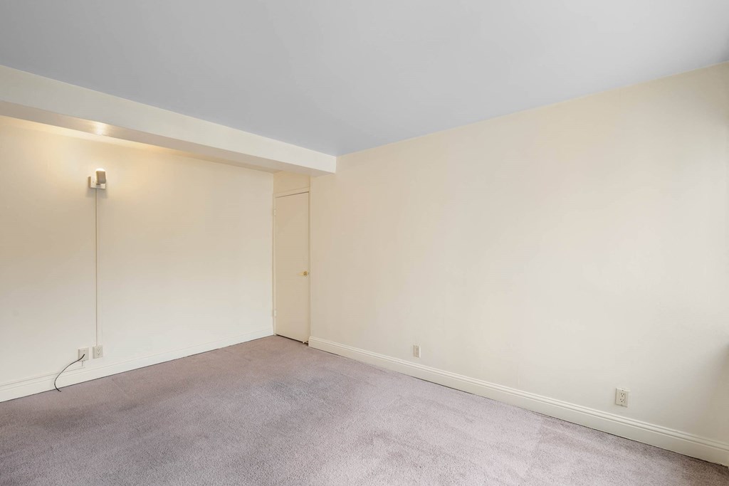 a living room with white walls and a carpet at Celio Apartments, Portland, OR