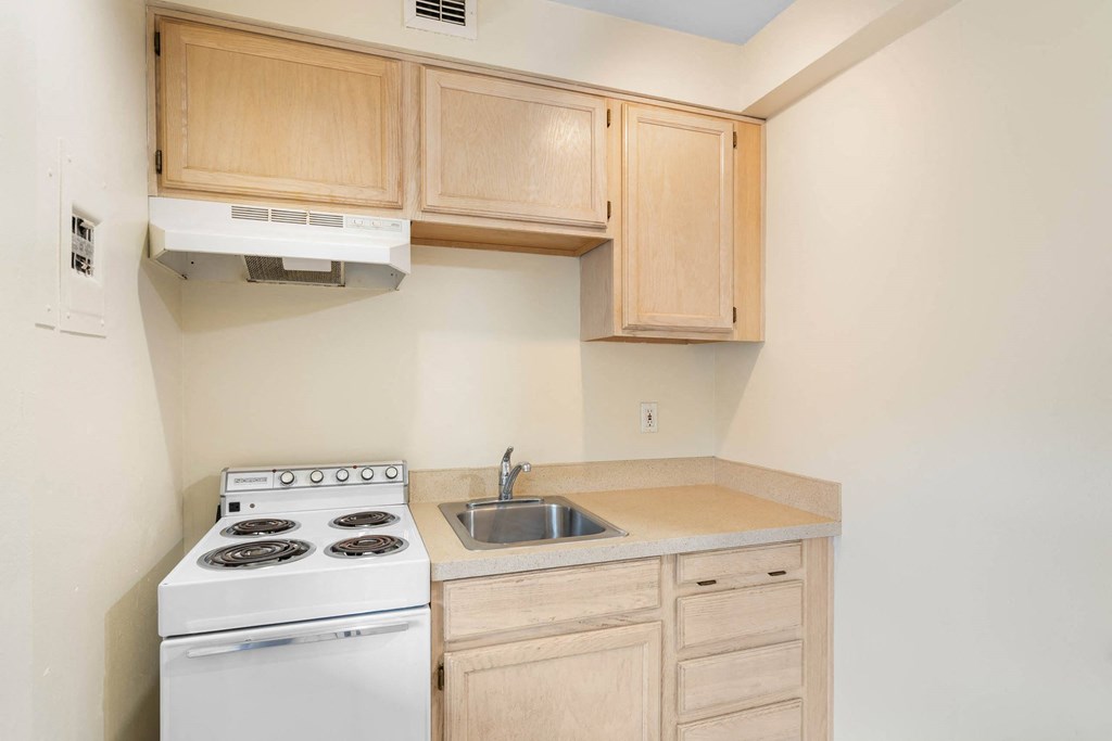 a kitchen with white appliances and wooden cabinets at Celio Apartments, Portland, Oregon