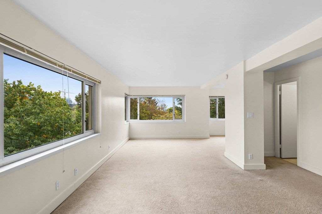 the living room has large windows and a carpeted floor at Celio Apartments, Portland, 97205