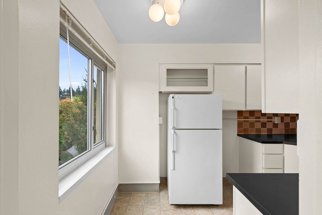 a kitchen with a refrigerator and a window at Celio Apartments, Portland, OR