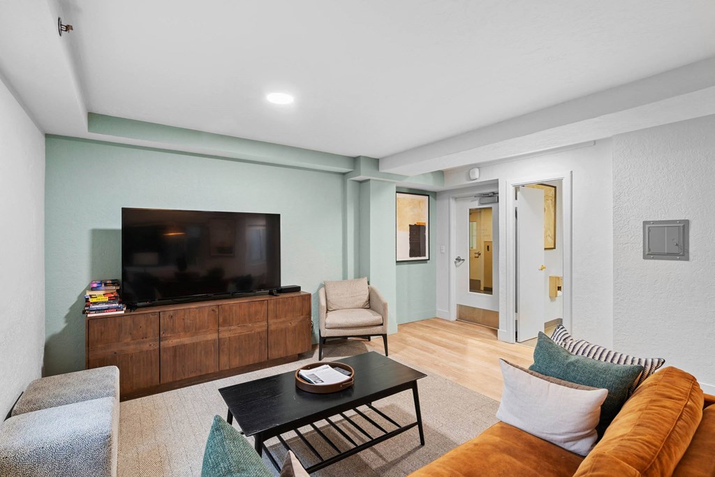 a living room with a couch and a tv at Celio Apartments, Portland, Oregon