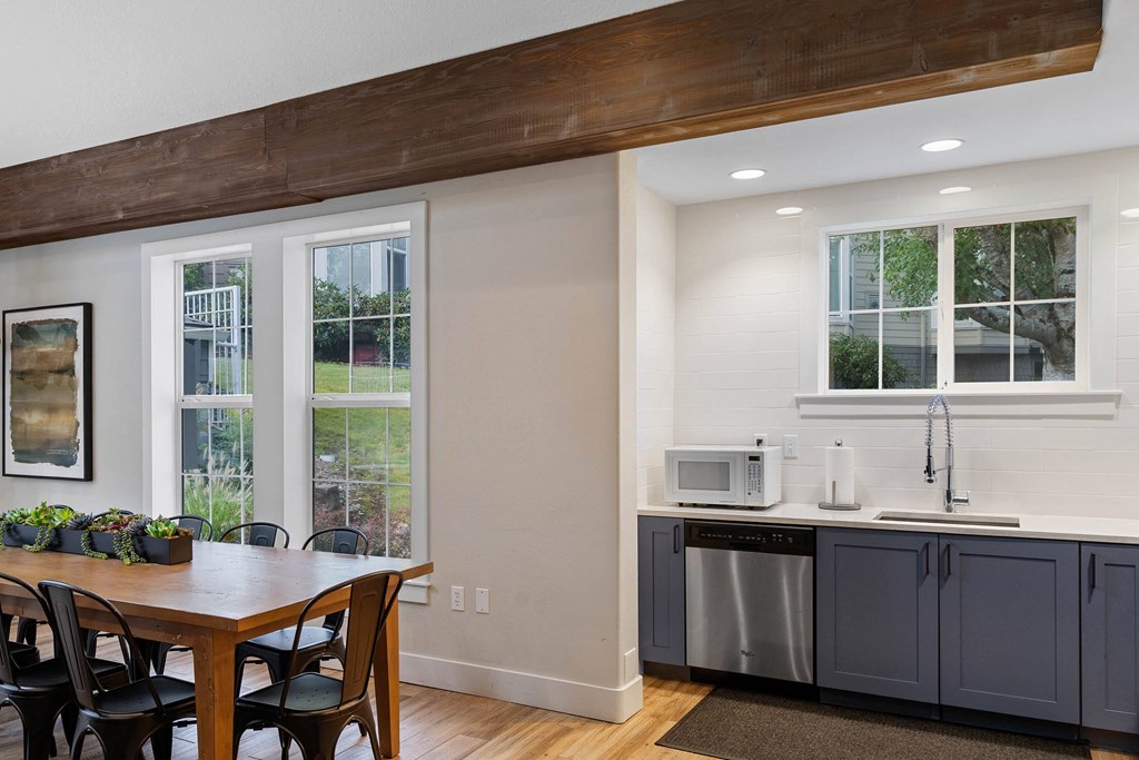 a kitchen with a table and a counter with two microwaves