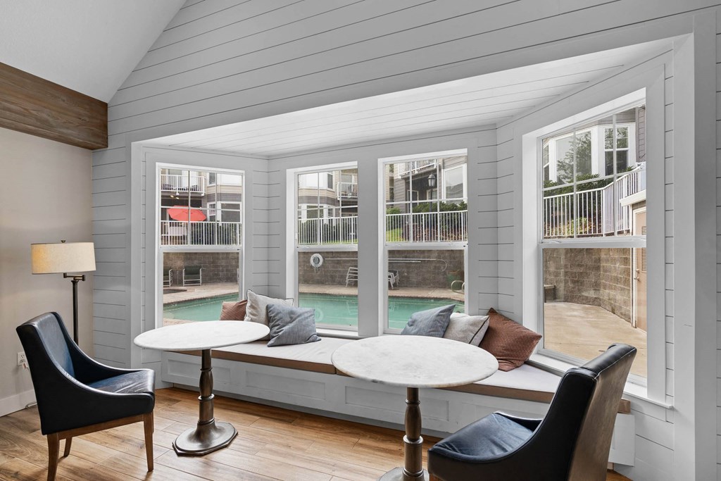 a screened in porch with tables and chairs and a pool