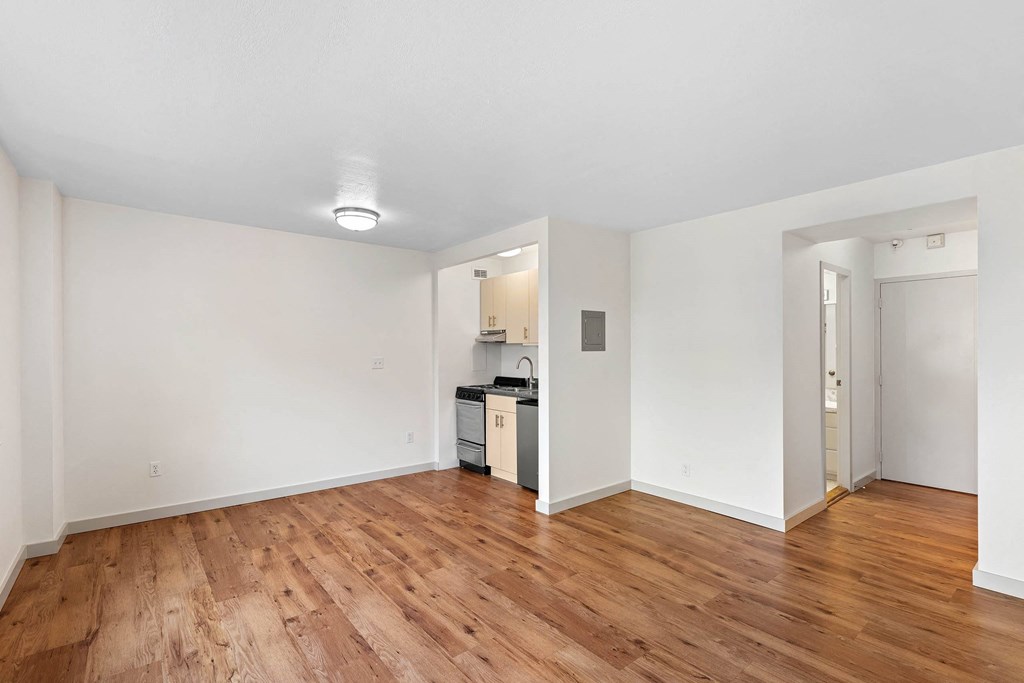 a living room and kitchen with wood floors and white walls at Vista St. Clair, Portland, 97205