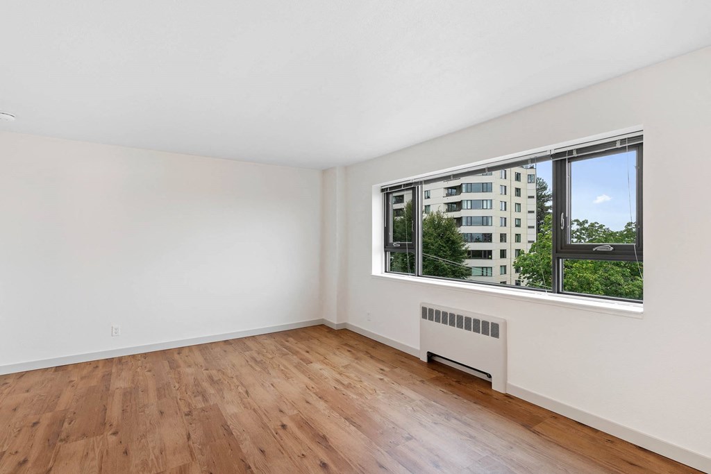a living room with wood floors and a large window at Vista St. Clair, Portland, OR, 97205